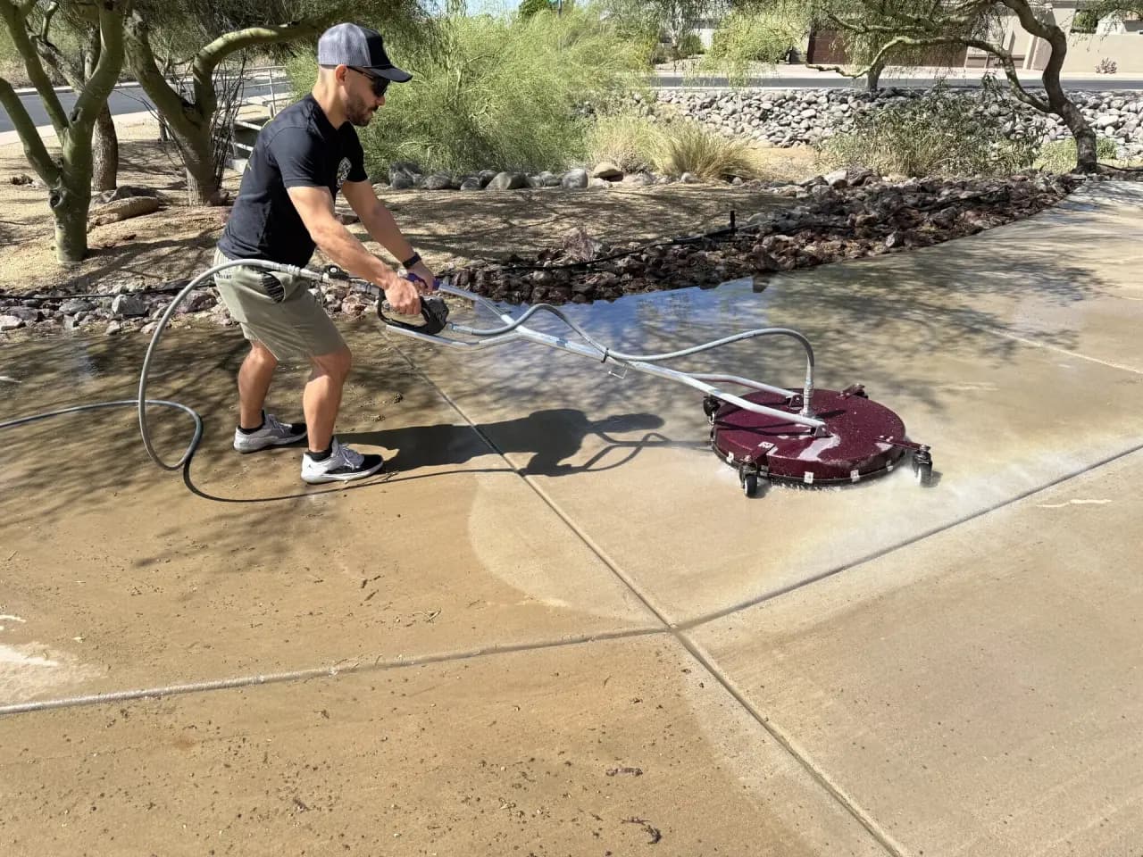 Diamondback technician using a commercial surface cleaner on an Arizona driveway